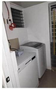 a white printer in a room with a window at Flia Alcantara CG in Naiboa