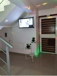 a living room with a tv on the wall at Flia Alcantara CG in Naiboa