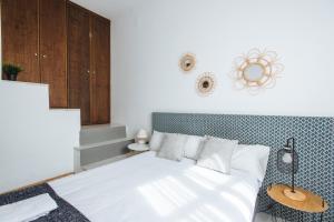 1 dormitorio con cama blanca y pared de color azul en Increible Casa Independiente en Santa Cruz, Parking Optional, en Sevilla