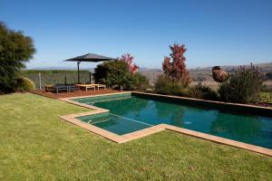 a swimming pool in a yard with a table and an umbrella at 187 Merrijig in Merrijig