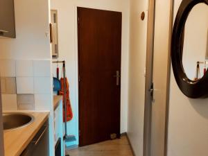 a bathroom with a sink and a brown door at Studio Villard-de-Lans, 1 pièce, 4 personnes - FR-1-689-118 in Villard-de-Lans