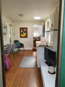 a kitchen and living room with a television and a table at Newly rennovated Granny flat in leafy foothills. in Clapham