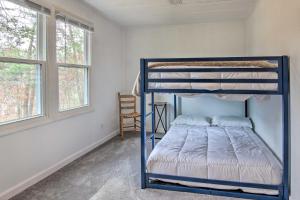 Litera azul en una habitación con 2 ventanas en Cozy Asheville Cottage with Grill and Fire Pit!, en Asheville