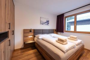 ein Schlafzimmer mit einem großen Bett mit Handtüchern darauf in der Unterkunft Am Römerweg - Appartements in Sankt Anton am Arlberg