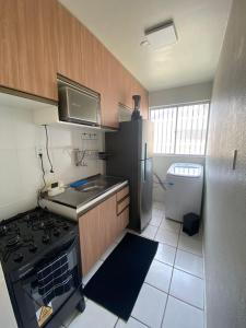 a small kitchen with a stove and a refrigerator at Apto refúgio 301 em São Luís/MA (inteiro) in São Luís