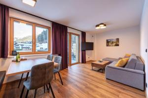ein Wohnzimmer mit einem Sofa und einem Tisch in der Unterkunft Am Römerweg - Appartements in Sankt Anton am Arlberg
