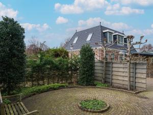 una casa con recinzione e patio in mattoni di Quaint Summer Holiday Home in Egmond Binnen a Egmond-Binnen