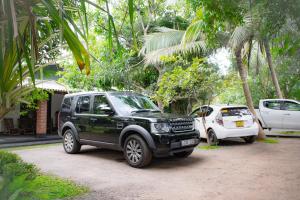 a black suv parked next to a white car at Green Cottage in Anuradhapura