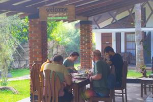 a group of people sitting at a table in a patio at Green Cottage in Anuradhapura
