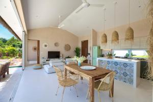 a kitchen and living room with a wooden table and chairs at Tropical Seaview Villa with Pool in Koh Samui 