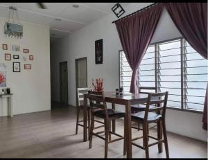 ein Esszimmer mit einem Holztisch und Stühlen in der Unterkunft Raintown inn taiping in Taiping