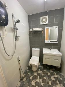 een badkamer met een douche, een toilet en een wastafel bij Raintown inn taiping in Taiping