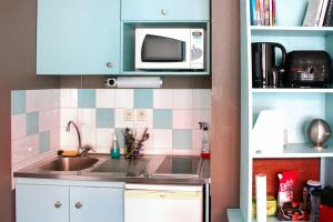 a kitchen with a sink and a microwave at Studio 22 square meters In The Center Of Lyon in Lyon