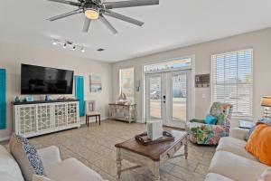 a living room with a couch and a tv at Blue Oasis Beach Vacation Home with Private Pool & Hot Tub in Panama City Beach