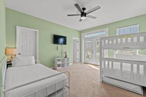 1 dormitorio con 1 cama y ventilador de techo en Blue Oasis Beach Vacation Home with Private Pool & Hot Tub en Panama City Beach