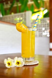 una copa con una rodaja de naranja en una mesa con flores en 37 Sunset Village Bali, en Canggu