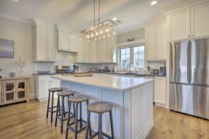a kitchen with white cabinets and a large island with bar stools at Long Branch Home Less Than 1 Mi to Beach! in Long Branch