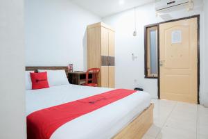 占碑市RedDoorz near Tugu Pers Jambi的一间带大床和书桌的卧室