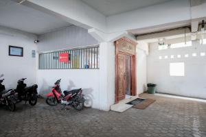 un grupo de motocicletas estacionadas en una habitación con puerta en RedDoorz near Tugu Pers Jambi en Jambi