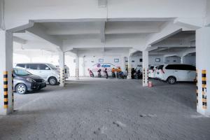 占碑市RedDoorz near Tugu Pers Jambi的停车场内停放汽车和摩托车 更多14张照片