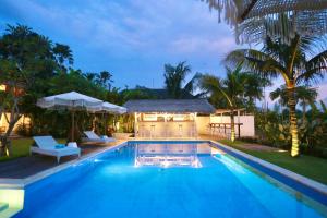 a swimming pool in front of a villa at 37 Sunset Village Bali in Canggu