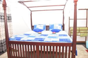 a bed with a blue comforter and blue pillows at Neo Grand Villa in Galle
