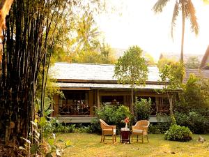 a house with chairs and a table in front of it at My Dream Boutique Resort in Luang Prabang