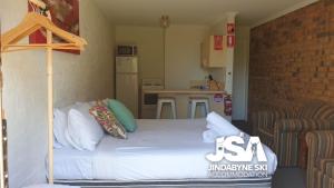een kleine slaapkamer met een bed met kussens erop bij Ellswood 1 in Jindabyne
