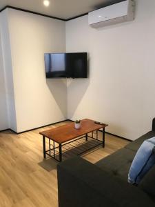 a living room with a table and a tv on the wall at Broome Vacation Village in Broome +23 photos