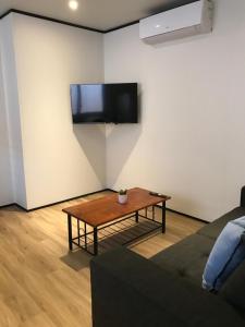 a living room with a table and a tv on the wall at Broome Vacation Village in Broome