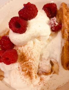 a piece of cake with whipped cream and raspberries at Repos & Manna Downtown Montréal in Montréal