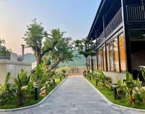 une passerelle devant un bâtiment avec des plantes dans l'établissement Eden Hotel Cát Bà, à Cat Ba