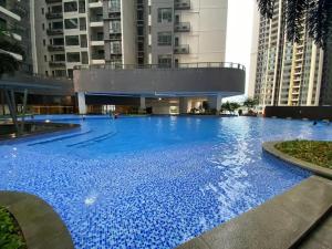 una gran piscina azul en un edificio con edificios altos en R&F Princess Cove Boutique Homestay By TREX #Nearby CIQ #Johor Bahru #JB Central #To custom 10minit, en Johor Bahru