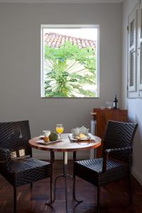 a table and chairs in a room with a window at Pousada Casa da Vitória in Salvador +37 photos
