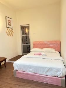1 dormitorio con 1 cama grande y cabecero rosa en The Explorers Guesthouse and Hostel, en Kuala Lumpur