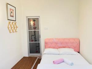 a bed with a pink headboard in a room at The Explorers Guesthouse and Hostel in Kuala Lumpur