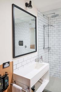 a white bathroom with a sink and a mirror at Laneways by Ovolo in Melbourne +34 photos