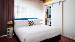a bedroom with a large white bed and a window at Laneways by Ovolo in Melbourne