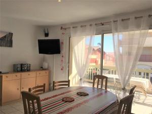 a dining room with a table and a balcony at Appartement Vieux-Boucau-les-Bains, 2 pièces, 4 personnes - FR-1-379-74 in Vieux-Boucau-les-Bains