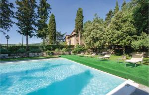 een zwembad in een tuin met stoelen en een huis bij Armeria in Anghiari