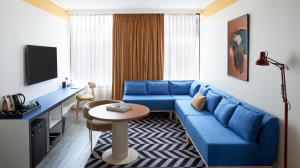 a living room with a blue couch and a table at Laneways by Ovolo in Melbourne
