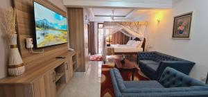 ein Wohnzimmer mit einem TV und ein Schlafzimmer in der Unterkunft The Festival Fully Furnished Apartments in Mombasa