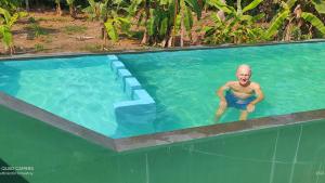 un homme debout dans une piscine dans l'établissement Kuttickattil Pool Home Stay Kumarakom, à Kumarakom