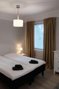 um quarto com uma cama com duas toalhas pretas em Koivikko Lifestyle Center em Mikkeli