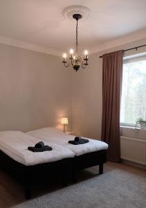1 dormitorio con 1 cama con 2 toallas negras en Koivikko Lifestyle Center, en Mikkeli