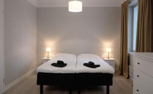 a bedroom with a bed with two black hats on it at Koivikko Lifestyle Center in Mikkeli