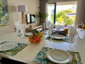 - une table à manger avec des assiettes et des verres dans l'établissement Tropical beachfront apartment, à Belle Mare