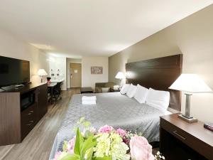 a hotel room with a large bed and a television at Ocean Star Inn in Sequim