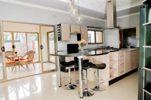 una cocina con una isla con taburetes en EMC Fully Furnished &Serviced Apartments 4 bedroom with a private Pool, Wifi ,Aircons & Dstv, en Lusaka