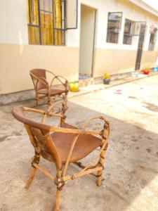 uma cadeira sentada no chão em frente a um edifício em Cozy studio apartment em Arusha